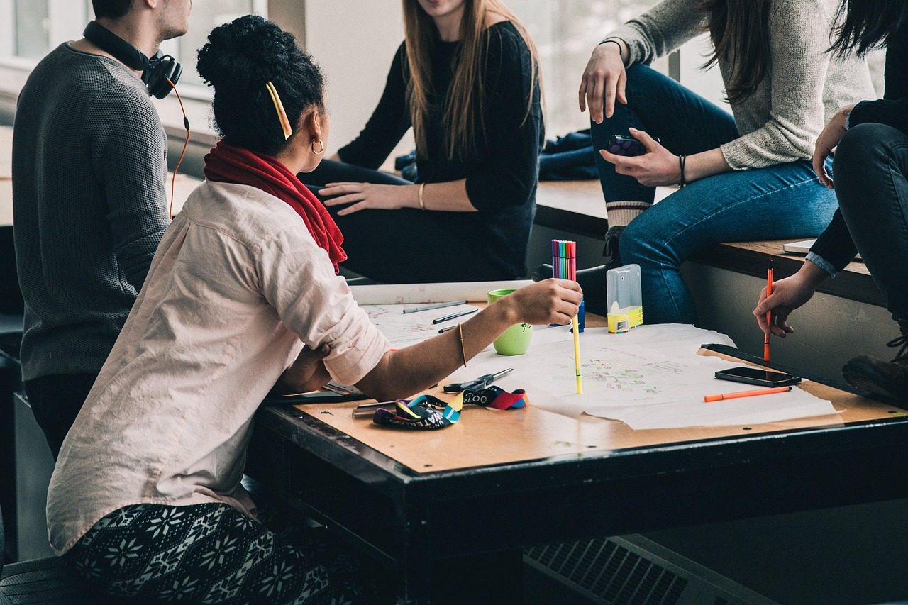 Schülerinnen und Schüler in Gruppenarbeit am Tisch